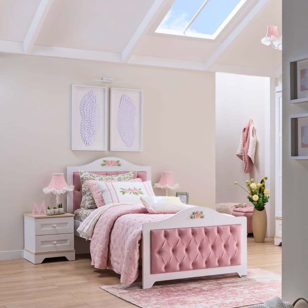 Детско легло Bianca в светла стая с розов текстил и меки пастелни детайли. Белият корпус и тапицираните панели създават уютна, спокойна атмосфера.